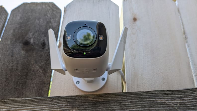 The Tapo camera installed on a wooden fence.