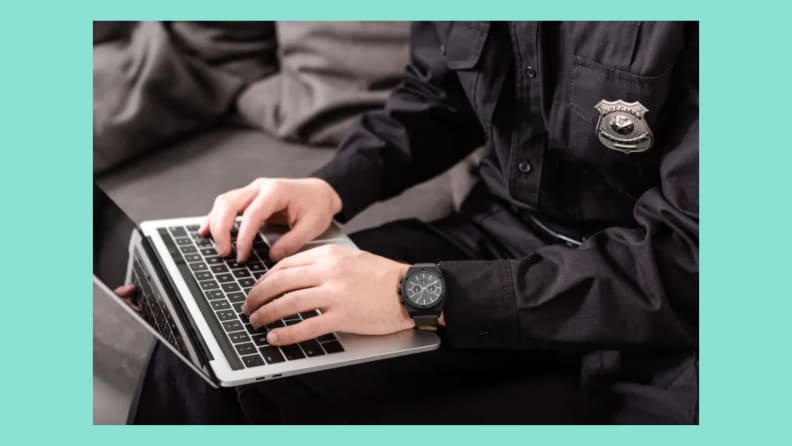 A person in a police uniform typing on a keyboard