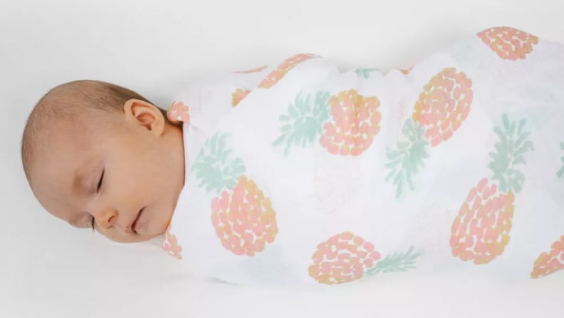 Baby wrapped in an Aden + Anais swaddle blanket