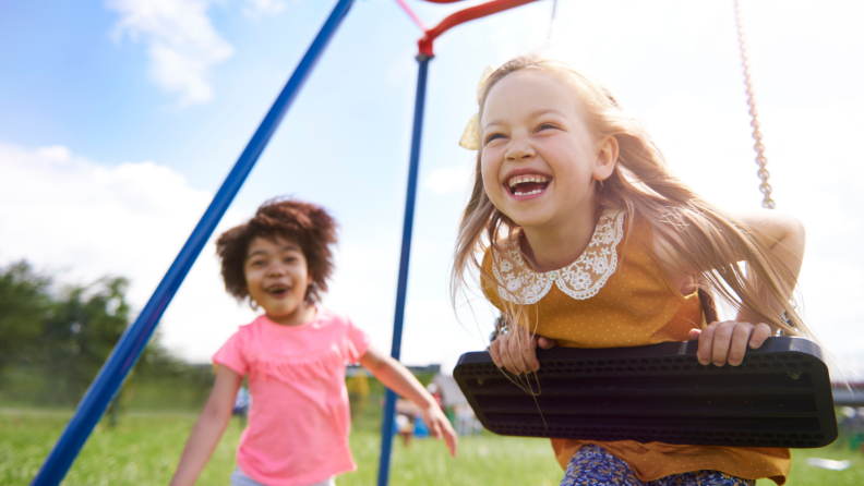 Two kids playing on a playground structure