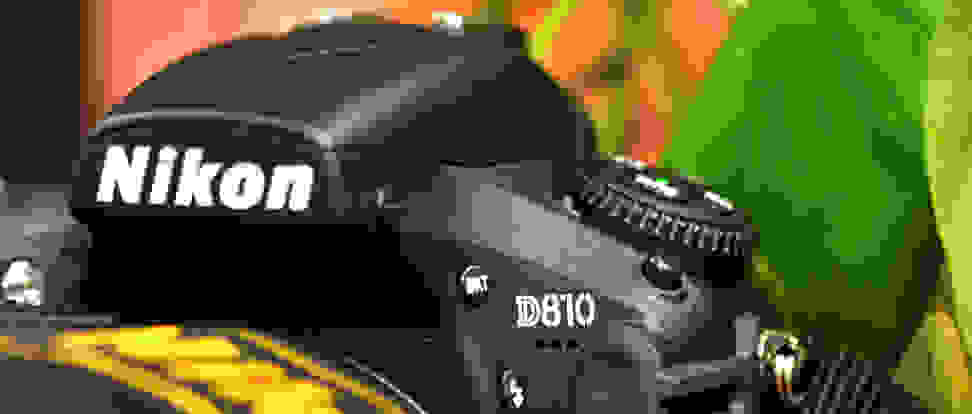 Close-up of the Nikon logo on a hefty DSLR camera.