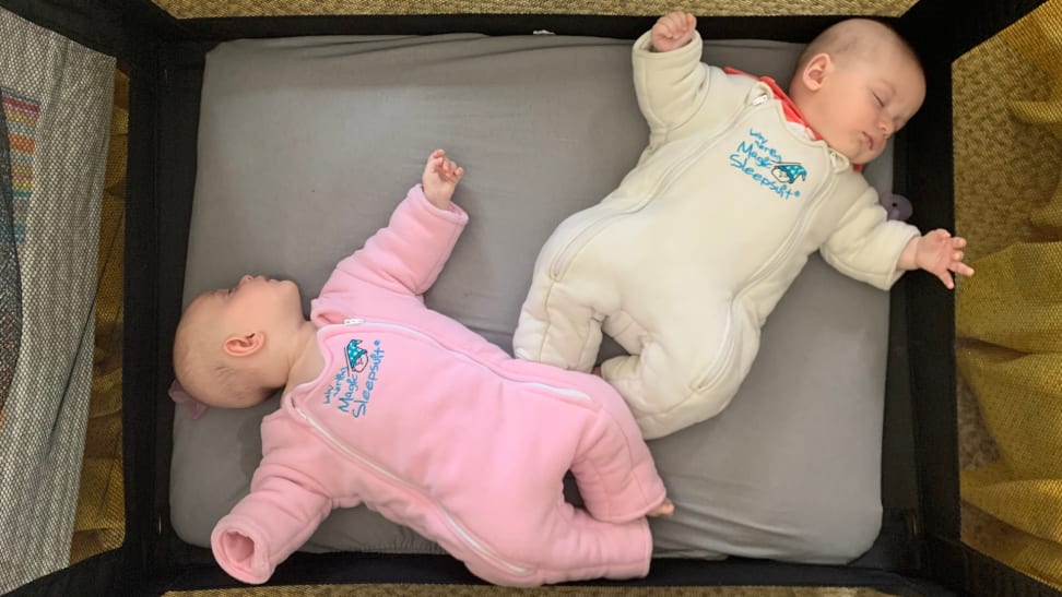 Two babies wearing Baby Merlin’s Magic Sleepsuit lay down for a nap.