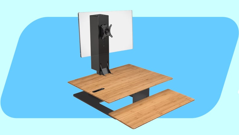 Uplift E7 standing desk converter on a blue background.