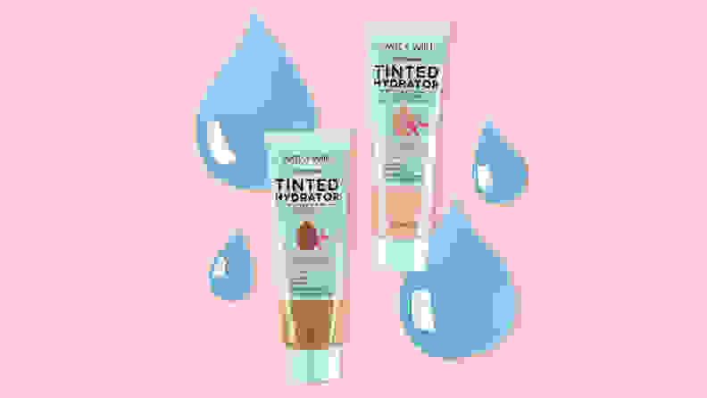 Two Wet n Wild Bare Focus Tinted Hydrators in light and dark skin tones sitting on top of a light pink background with animated water droplets in back of them.