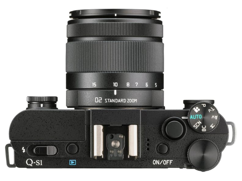The Pentax Q-S1 retains the pop-out flash, hot shoe, and top plate control cluster from the Q7.