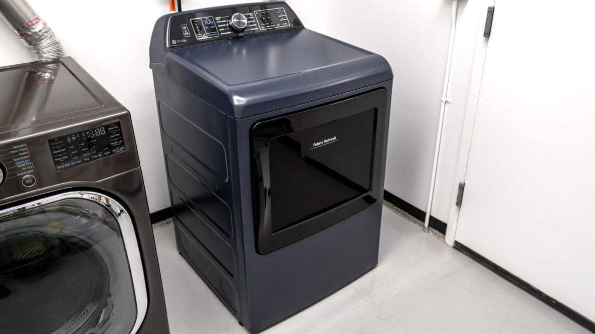 Product shot of black GE Profile PTD90EBPTRS 900 Series Dryer in testing lab next to another washing machine.