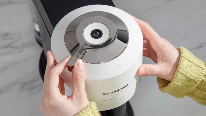 Person using hands to adjust the settings on the Nespresso Vertuo Next coffee maker.