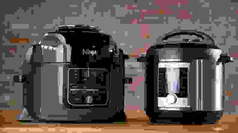 A Ninja Foodi pressure cooker and an Instant Pot Ultra pressure cooker sit side by side on a wooden surface.