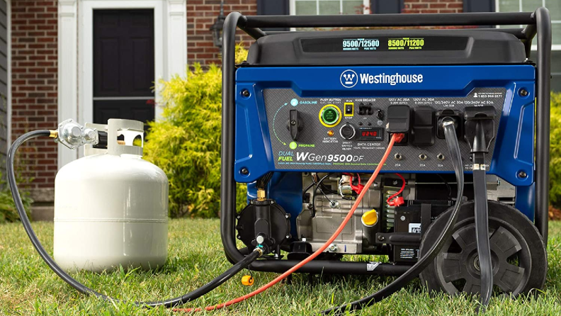 A portable generator sits in the foreground attached to a propane tank. In the background we can see a large house.