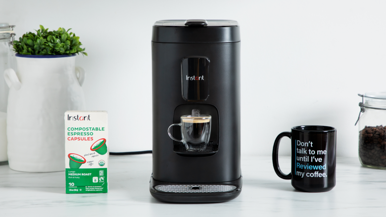 Product shot of the Instant Dual Pod Plus Coffee Maker with brewed cup of coffee under dispenser.