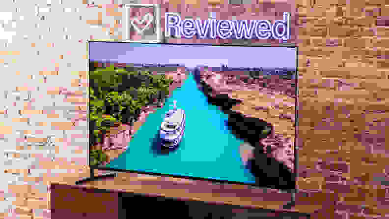 The Sony A95L QD-OLED TV displaying a high-resolution image of a boat moving along a bright, turquoise-colored river
