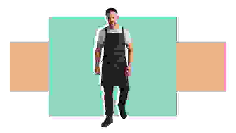 A man with an apron in front of a background.