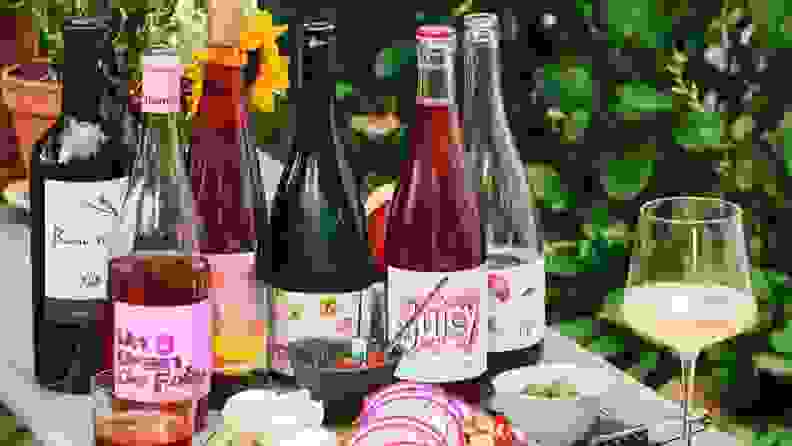 Bottles of red, white, and rosé wine arranged on a picnic table.