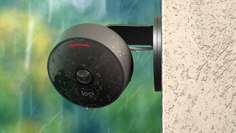 罗技公司的防风雨户外安全摄像头悬挂在一户人家的一侧。