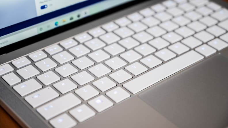 The laptop's keyboard is shown, white keys on a silver chassis.