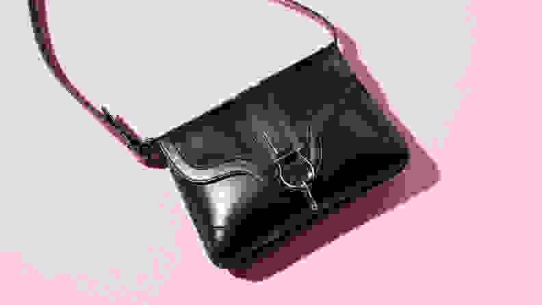 black shoulder bag on pink background