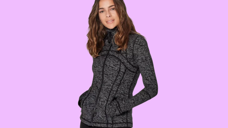 Photo of a woman wearing a jacket from Lululemon against a purple background.