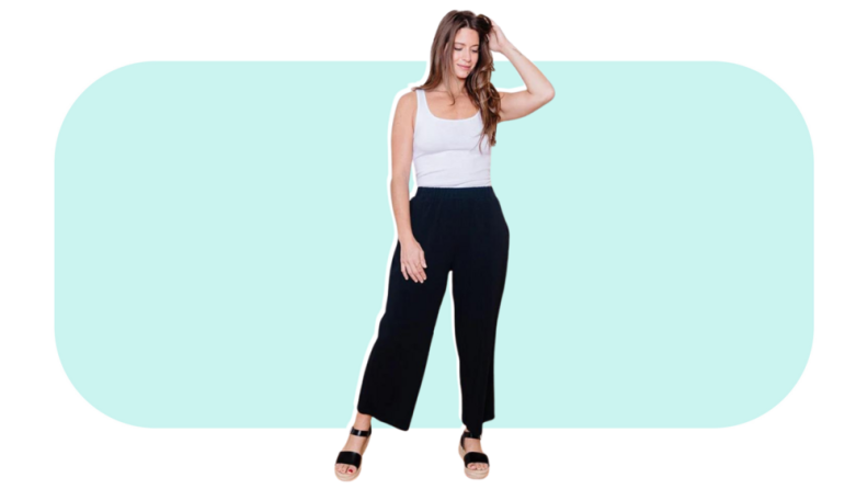 A model wearing black wide-leg pants with a white tank top.
