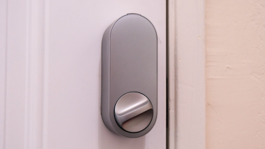 The Aqara U200 smart door lock shown in silver hanging on a white door.