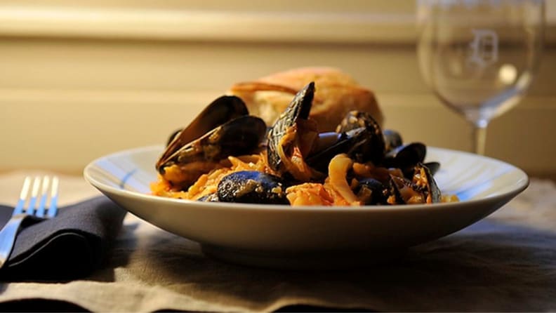 A plate of mussels that mimics a restaurant meal.