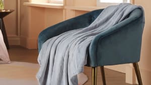 A throw blanket placed on a chair.