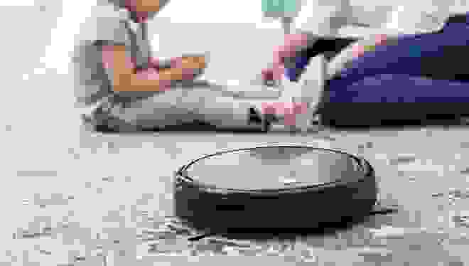 A Eufy 11S robot vacuum cleaning a carpet.