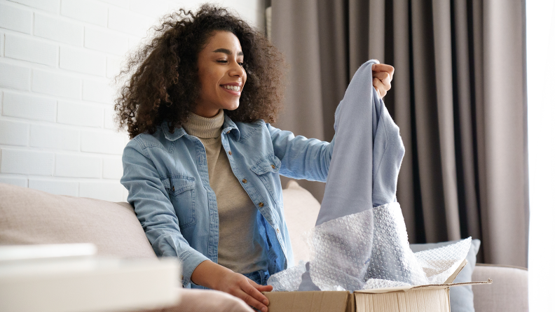 A woman removes a piece of clothing from a box