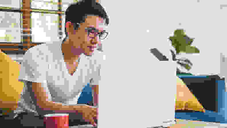 Young Asian man working with laptop at home