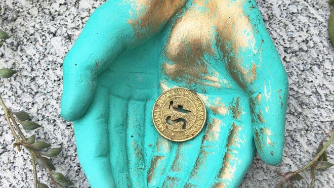 A teal and gold dish that resembles two hands cupped together.
