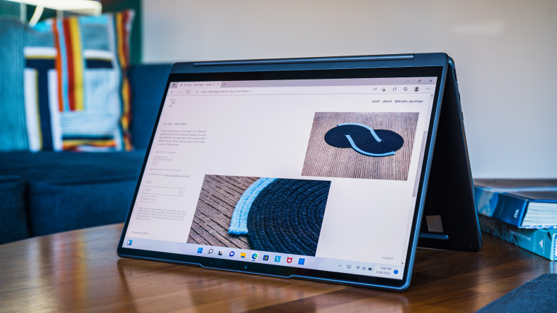 The laptop is propped up in tent mode on a table