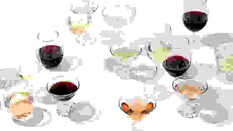 A variety of wines poured in a variety of glass shapes shot on a white background.