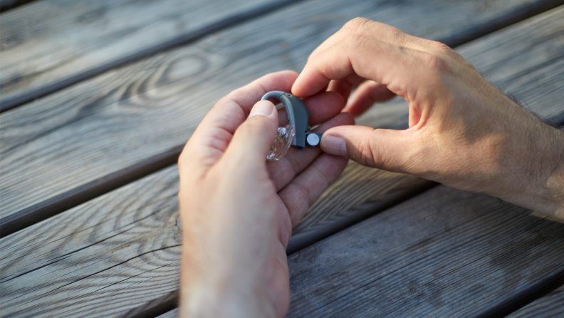 A hearing aid being held in hands