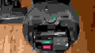 A black robot vacuum on a wood floor
