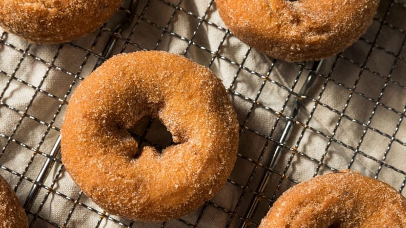 Apple cider doughnuts sit on a drying rack.