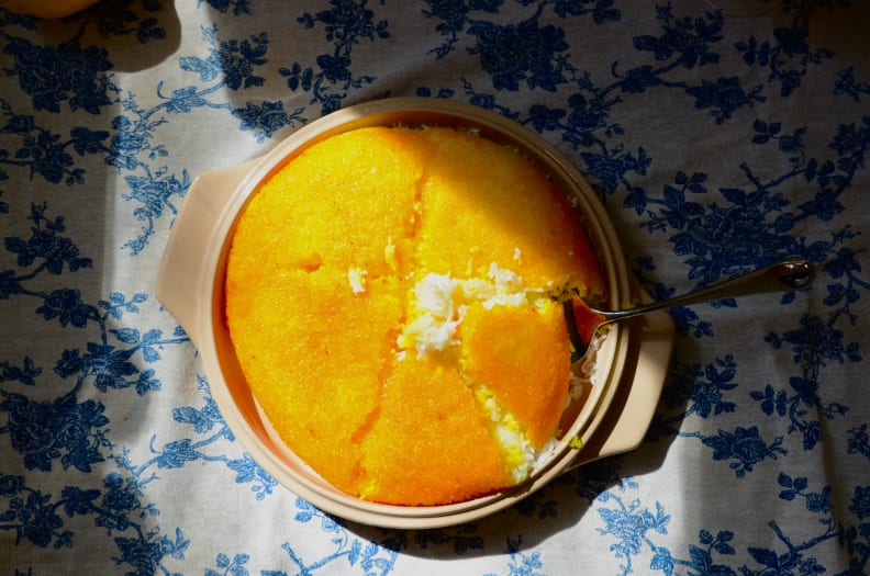 A plate of tahdig rice is placed against a blue and white backdrop.
