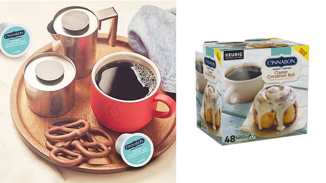 On left, coffee in red mug sitting next to chocolate covered pretzels, creamers and Cinnabon K-cups. On left box of Cinnabon K-cups