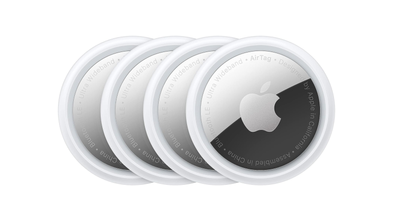 Four Apple AirTags arranged in a row in an overlapping fashion.