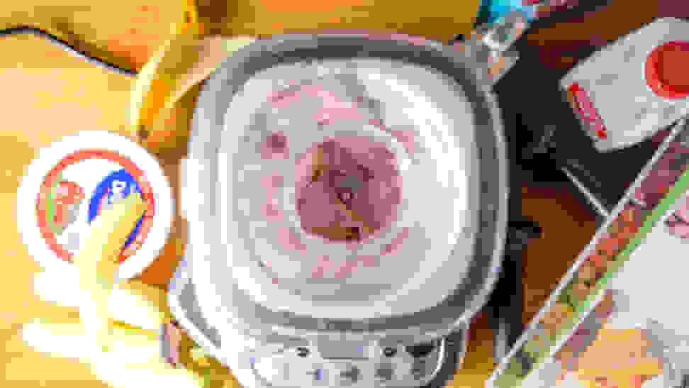 A blender viewed from above mixing a pink smoothie