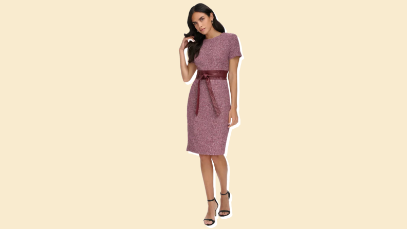 A sheath dress from Calvin Klein against a manila background.