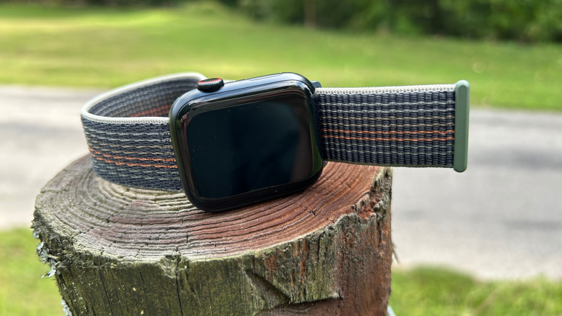 An Apple Watch on a tree stump.