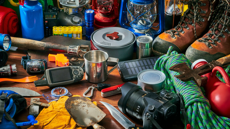 An assortment of camping equipment on a floor.