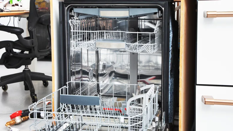 The Bosch 800 Series dishwasher open with dishes loaded inside.