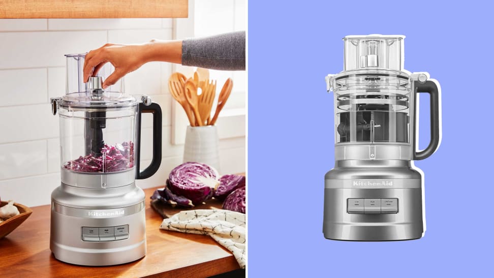 A KitchenAid 13-Cup Food Processor with its accessories on display in front of a colored background.