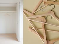 An empty closet next to a pile of empty hangers