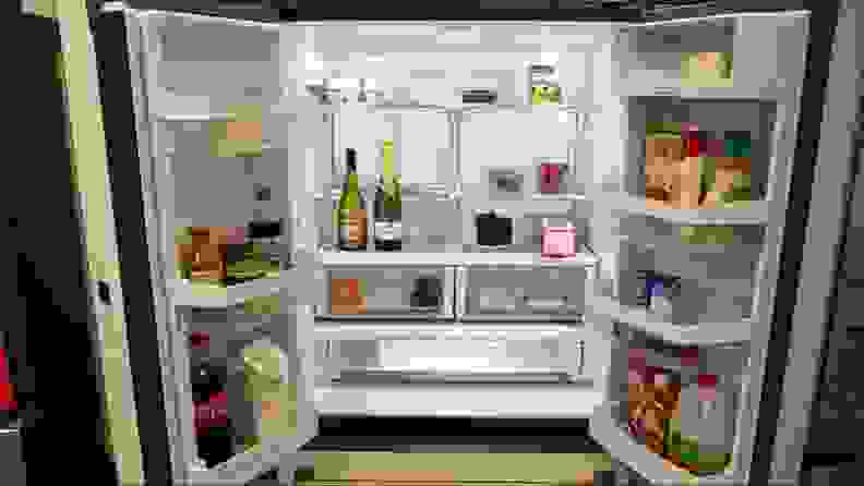 Open fridge with food and condiments inside.