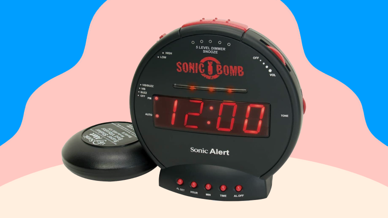 Circular black and red alarm clock with shaker attachment.