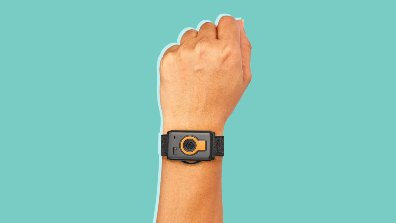 A hand wearing the CarePredict watch in front of a background.