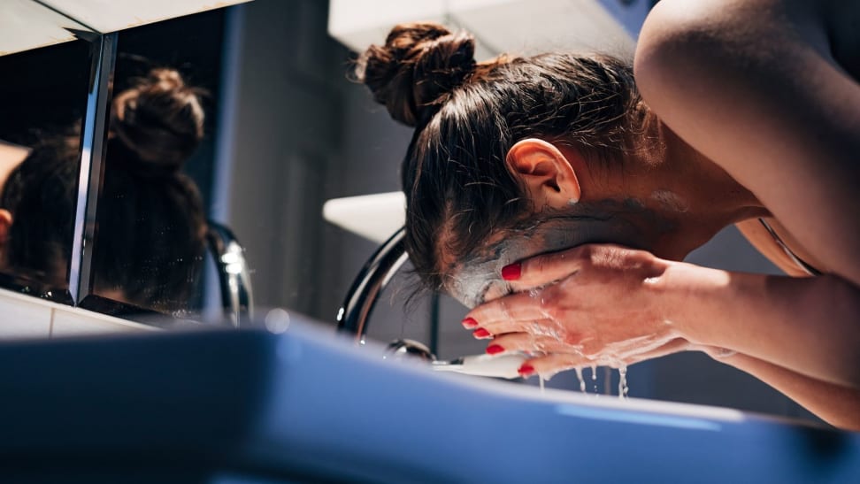 a woman washes her face in the evening