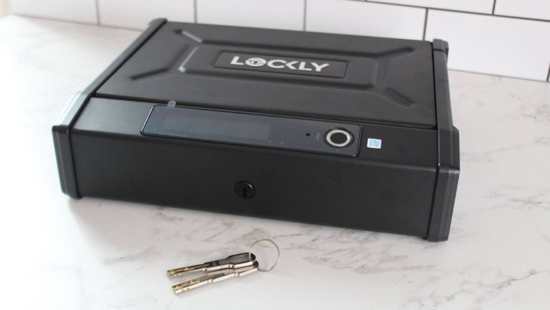 The Lockly Smart Safe on a marble counter with keys next to it.