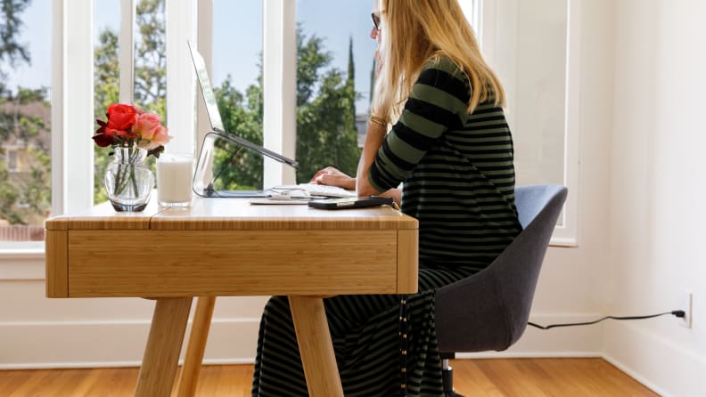 A woman sitting at a desk working on a computer